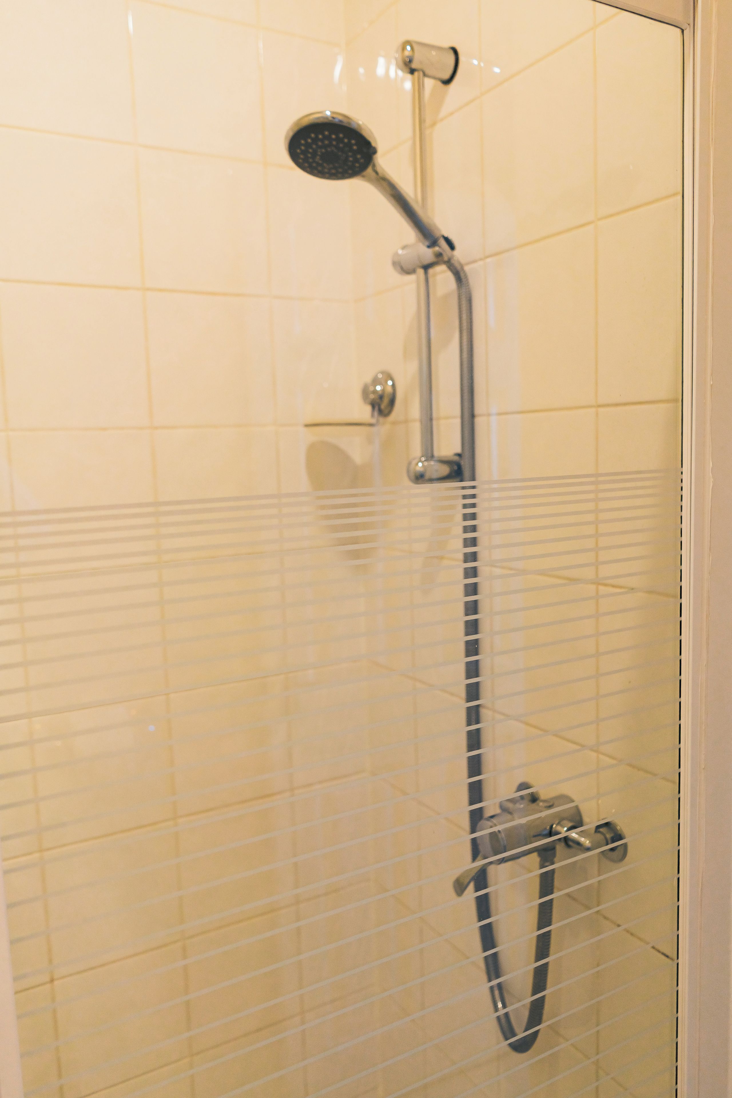 A shower with a handheld showerhead and a handheld hose.