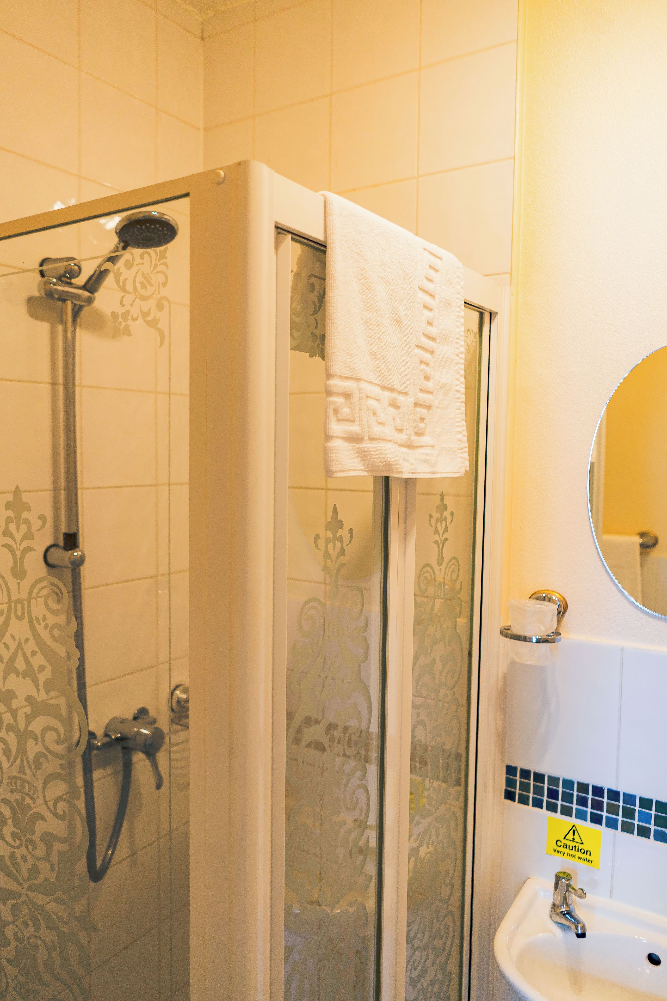 A bathroom with a shower, a sink, and a mirror.