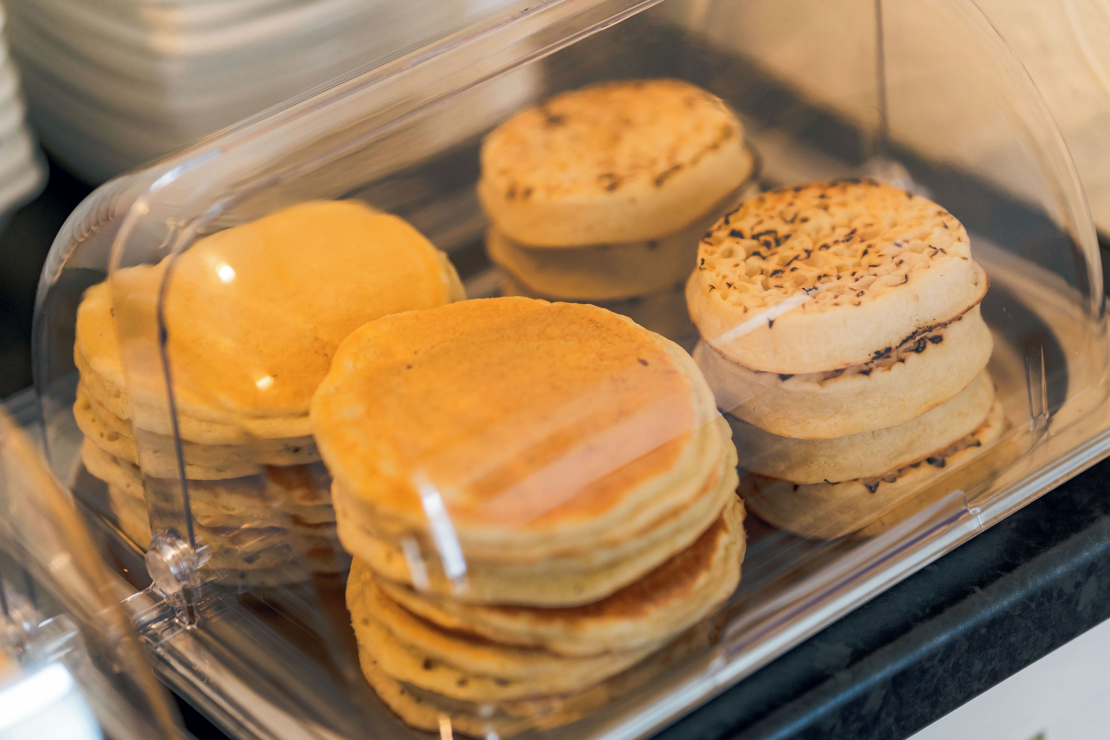 A clear plastic container holding several pancakes.