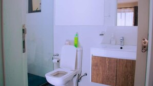 Ein Badezimmer mit Toilette, Waschbecken und Spiegel.