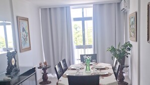 Ein Essbereich mit einem für sechs Personen gedeckten Tisch, umgeben von Stühlen, einer Speisekammer und einer Topfpflanze.