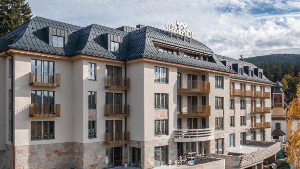 Ein mehrgeschossiges Hotel mit Balkonen und einer Steinaußenwand.