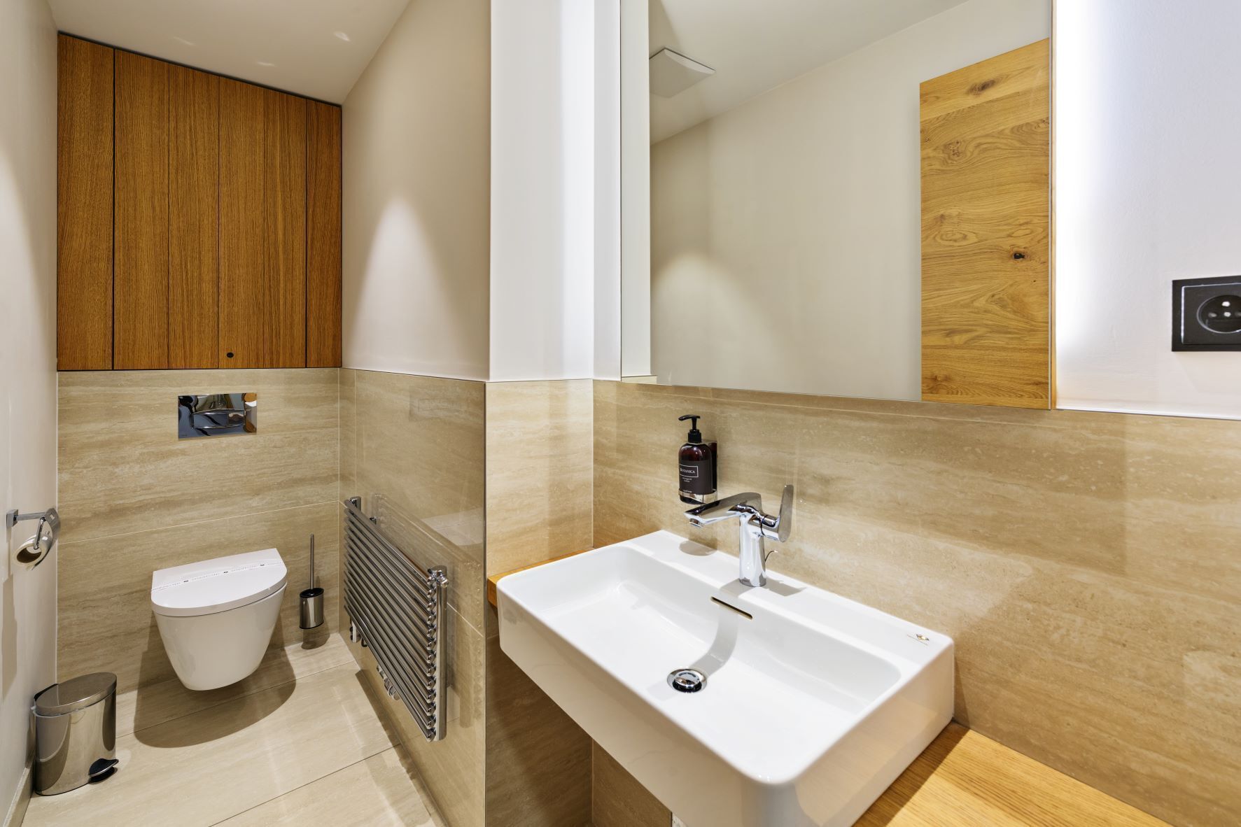 A modern bathroom with a toilet, a sink, and a mirror.