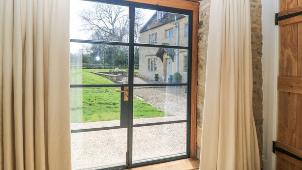 Quarto com uma grande porta de vidro deslizante que dá para um jardim.