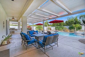 A covered patio with outdoor furniture and a pool. - Gated Rancho Mirage Oasis w/ Pool & Spa (Rancho Mirage)