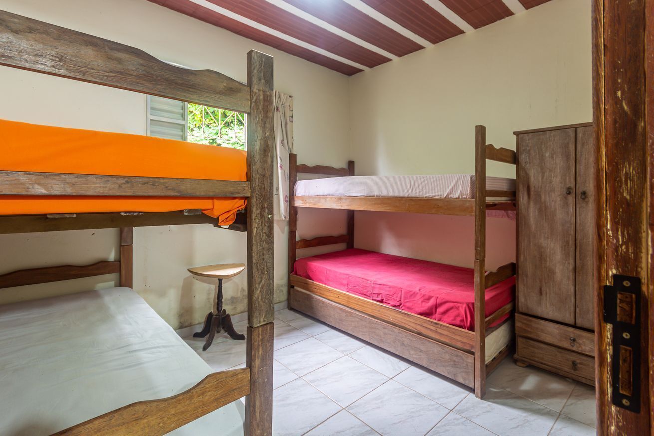 Un dormitorio con literas, una mesita pequeña y un armario de madera.