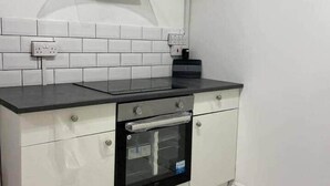 A kitchen with a built-in oven, a stainless steel range hood, and white subway tiles on the backsplash. - Double bedroom with ensuite 1 stop to Excel and O2 (London)