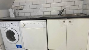 A compact kitchen with a washing machine, a sink, and white cabinets. - Double bedroom with ensuite 1 stop to Excel and O2 (London)