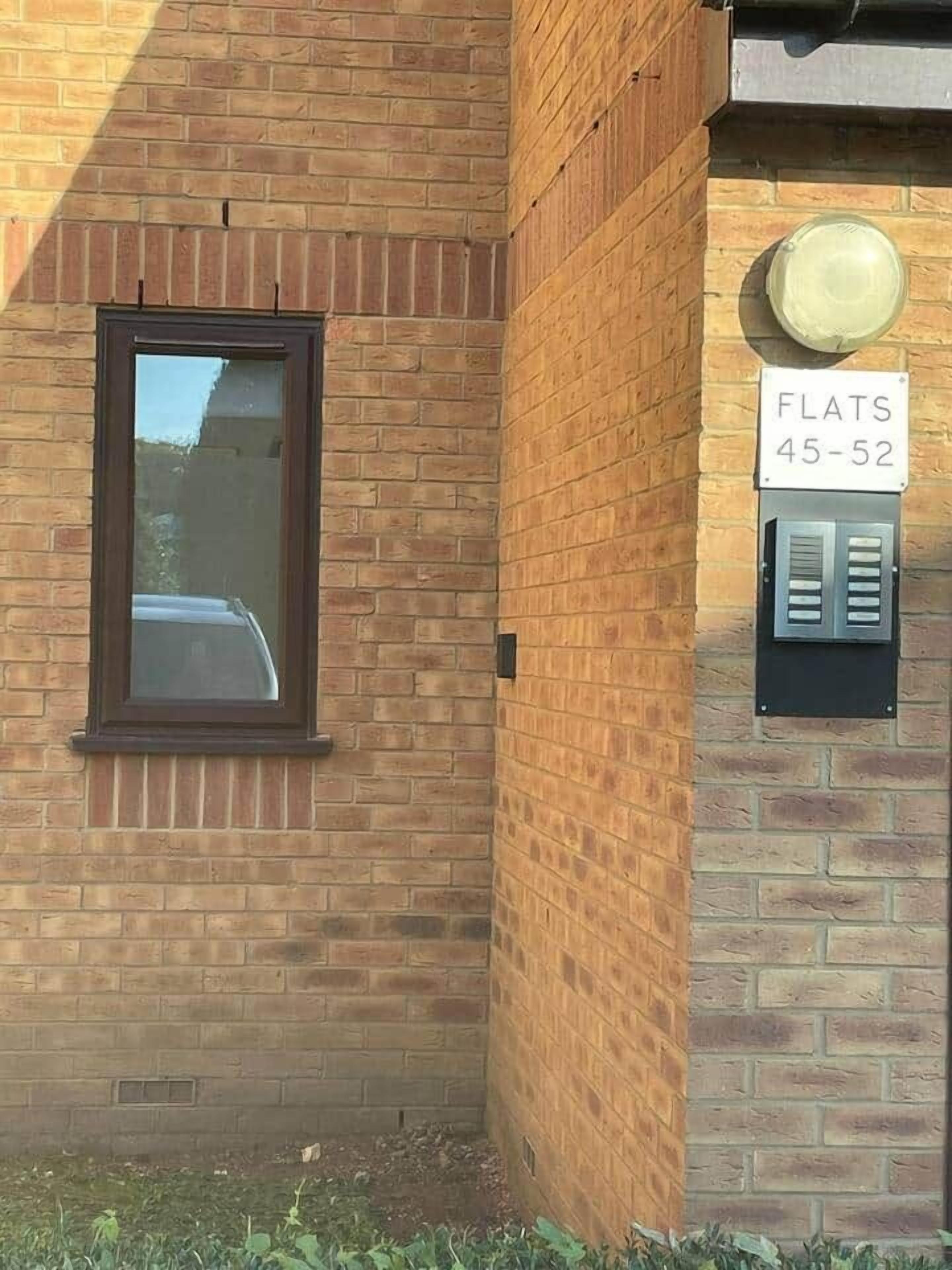 Ein Backsteinhaus mit einem Fenster und einem Schild, das Wohnungen 45 bis 52 anzeigt.