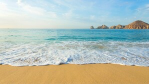 Uma praia com águas azuis cristalinas e areal dourado.