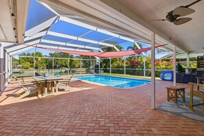 Screened pool patio with brick pavers, swimming pool, dining table, and shade sail. - Newly appointed home w/Pool & Gulf Access (Sarasota)