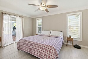 Bedroom with a plaid bed, ceiling fan, and sliding doors to the patio. - Newly appointed home w/Pool & Gulf Access (Sarasota)
