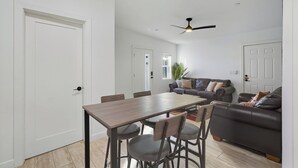 A modern living room with a dining table, chairs, a sofa, and a ceiling fan. - Cozy One Bedroom Oldtown EV Charger Shared Space (Scottsdale)