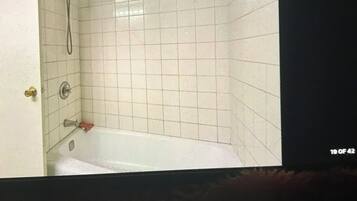 A bathroom with a bathtub, a shower, and a toilet.