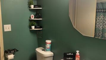 Een badkamer met een toilet, een wastafel en planken met toiletartikelen.