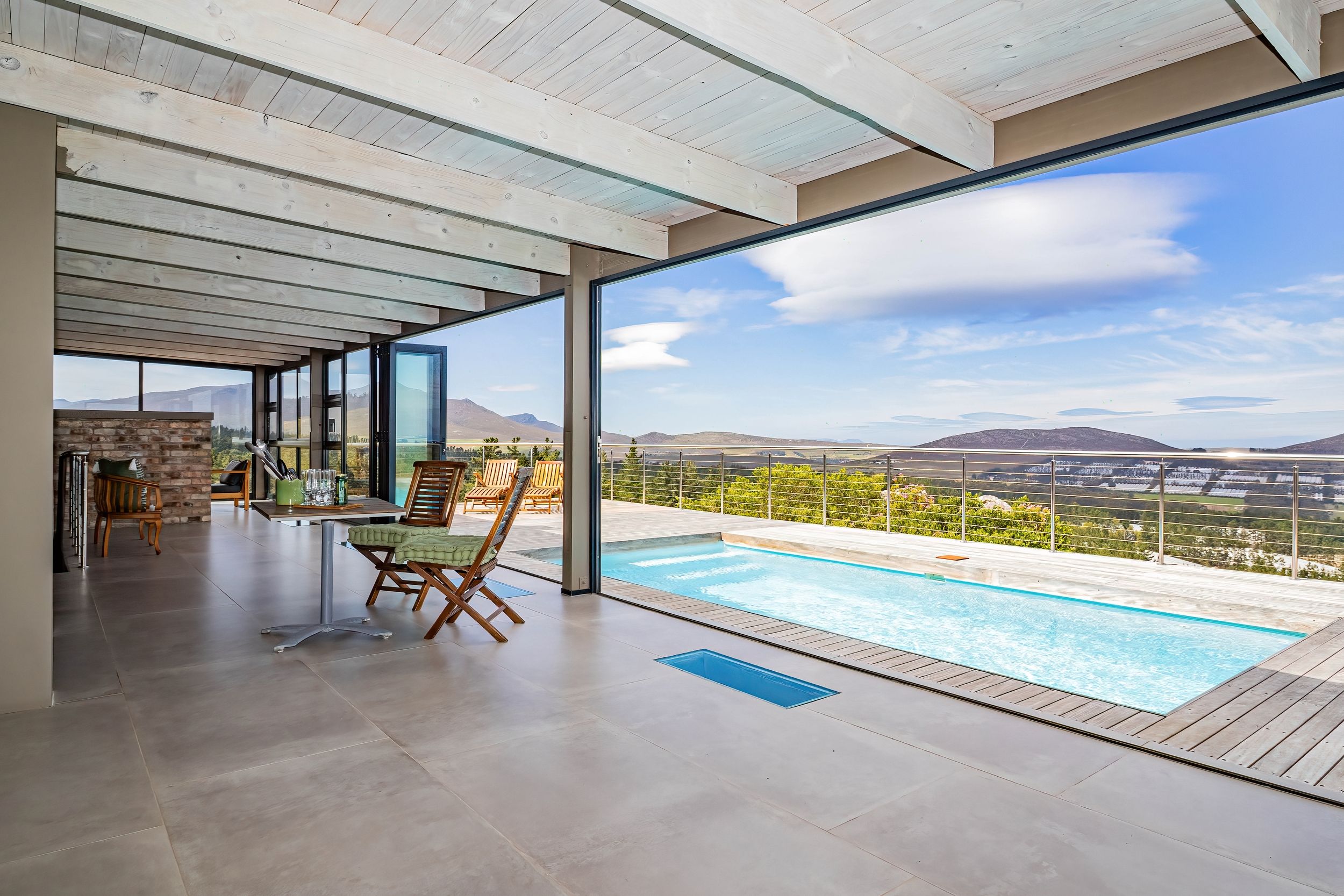 Ein moderner Poolbereich im Freien mit freiem Blick auf die umliegende Landschaft.