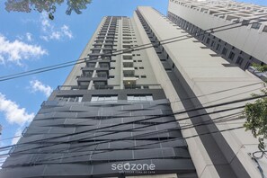 Un edificio moderno di grandi dimensioni, caratterizzato da un design architettonico innovativo, numerosi balconi e una facciata in metallo di rilievo.