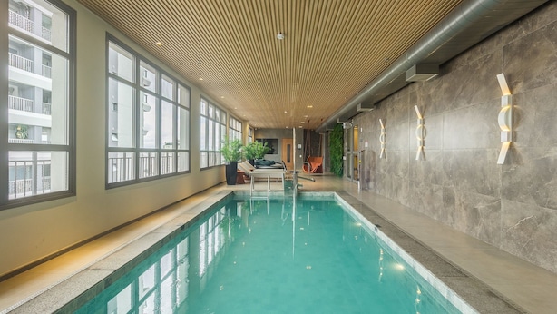 A swimming pool with a wooden ceiling, large windows, and a stone wall. - High-standard Studio 800m From the Metro Ihl0501 (São Paulo)