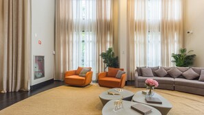 A spacious living area with two orange armchairs, a grey sofa, and a coffee table with decorative items. - High-standard Studio 800m From the Metro Ihl0501 (São Paulo)