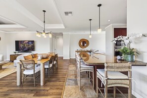 A modern living room with a dining area, wooden flooring, and contemporary furniture. - Spacious Ocean View condo with AC in Mauna Kea Resort (Waimea)