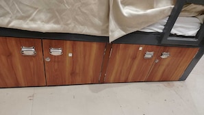 A wooden wardrobe with multiple compartments and metal handles. - S. G. P Dormitory (Mathura)