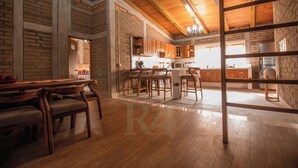 Une cuisine spacieuse avec des meubles en bois, un coin repas doté d’une table et de chaises en bois, et un îlot de cuisine bien visible.