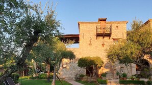 A stone building with a balcony, surrounded by well-maintained gardens and a paved pathway. - Grantzaos Villas Zante (Agios Sostis)
