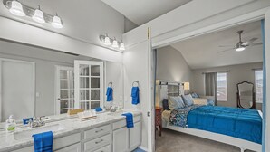 A modern bathroom with a large mirror, dual sinks, and a vanity. - Comfortable Cozy Retreat Prime North Location (Colorado Springs)