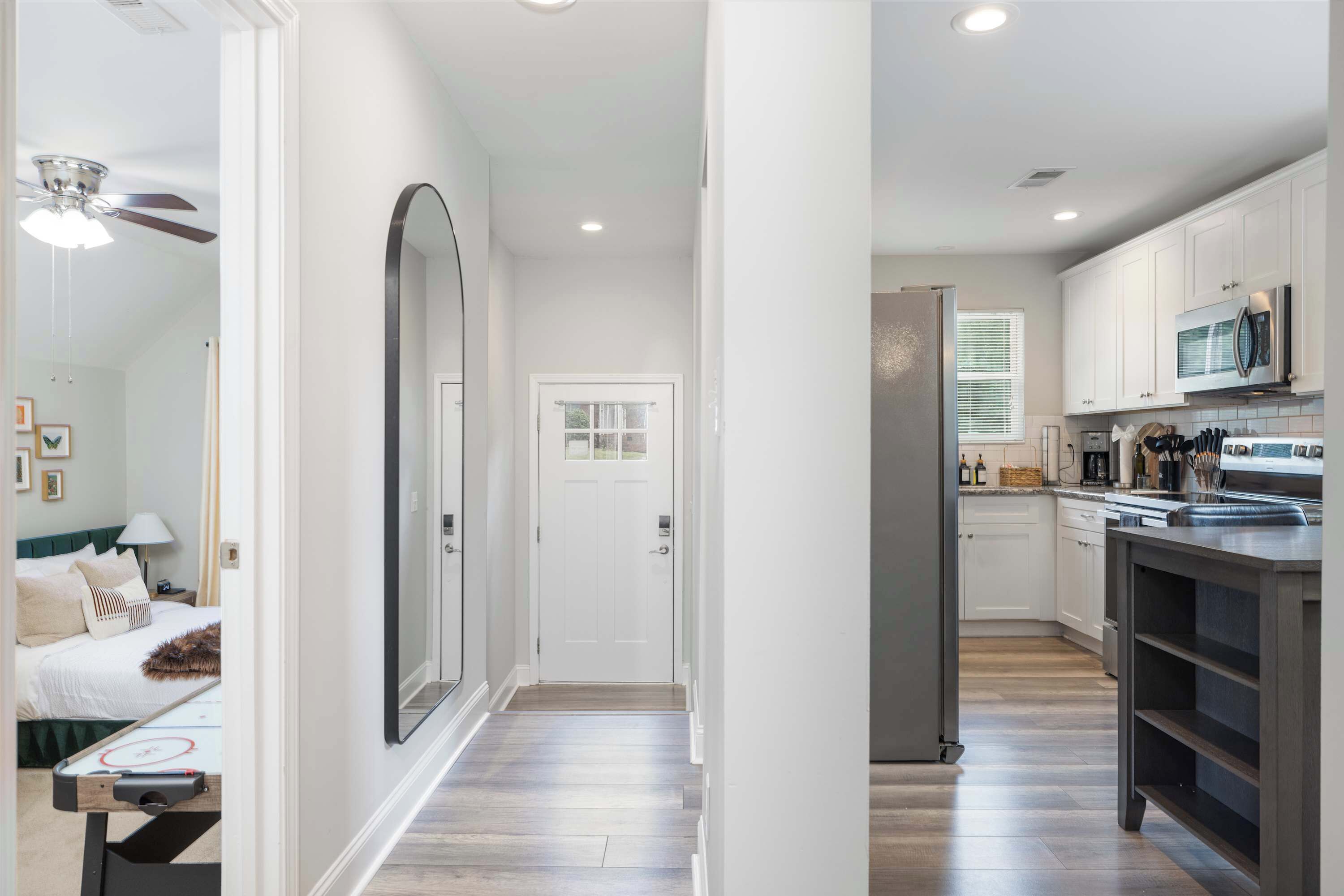 A modern kitchen with white cabinets, a microwave, and a refrigerator.