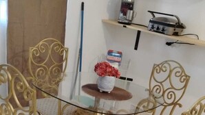A dining area with a glass-top table surrounded by four ornate chairs with patterned cushions. - Cozy 3-bedroom house in serene Carolina with AC (Carolina)