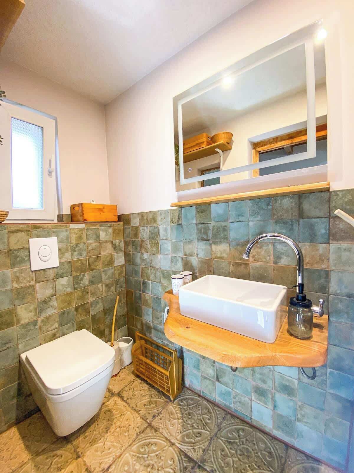 Un baño con un lavabo blanco, un espejo y un inodoro.