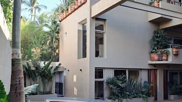 Alberca al aire libre, sombrillas en la alberca y camastros