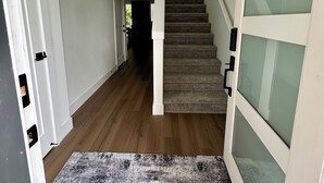 Un pasillo con una escalera alfombrada que conduce a otra habitación.