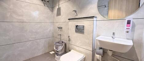 A modern bathroom with a toilet, bidet, and sink.