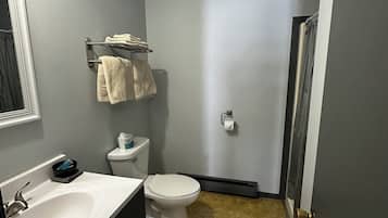 Un baño con inodoro, lavamanos y toallero.
