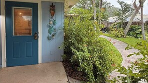 Una porta blu decorata con un gufo e una scultura di tartaruga a parete.