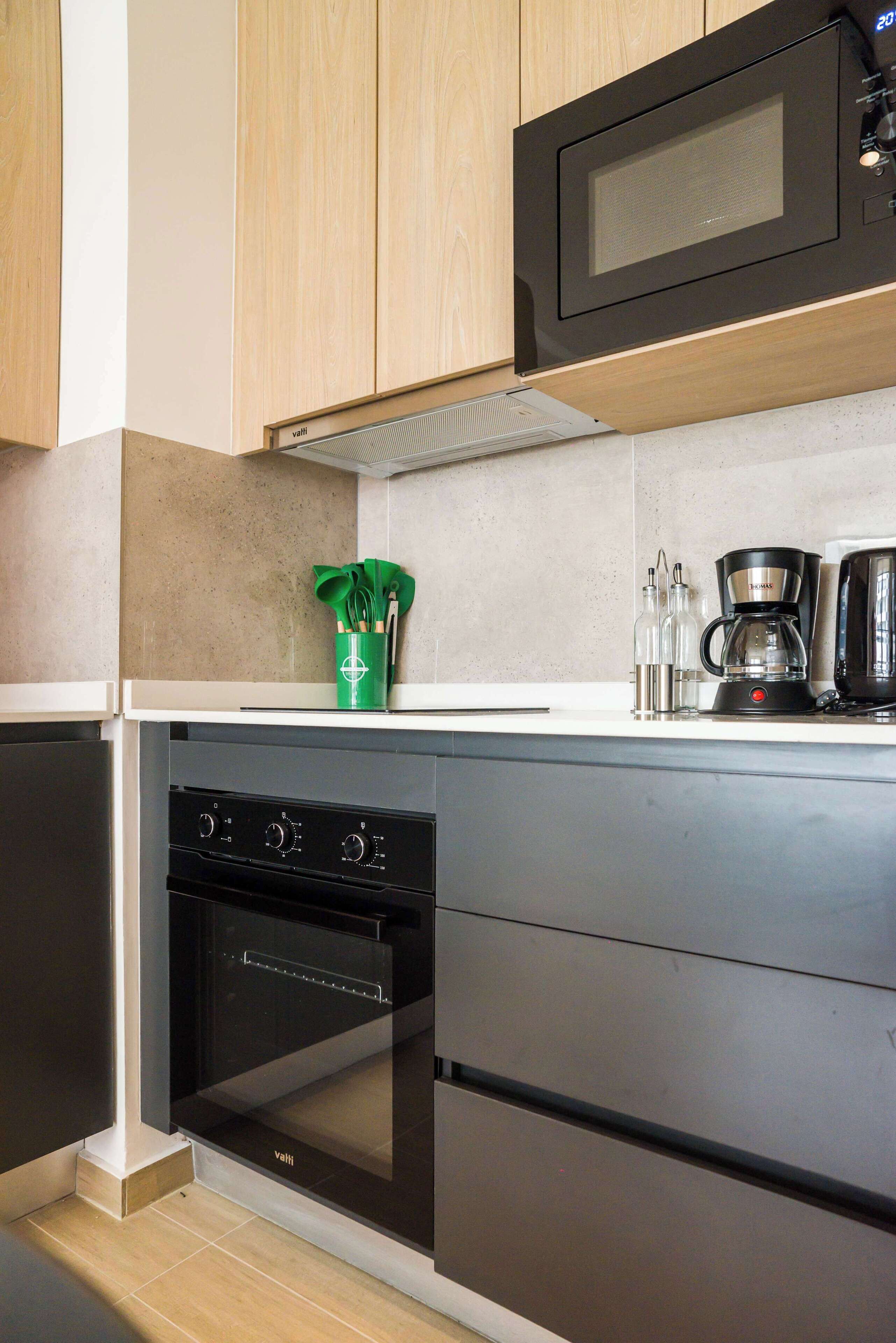 A modern kitchen with wooden cabinets, a microwave, a coffee maker, and a dishwasher.