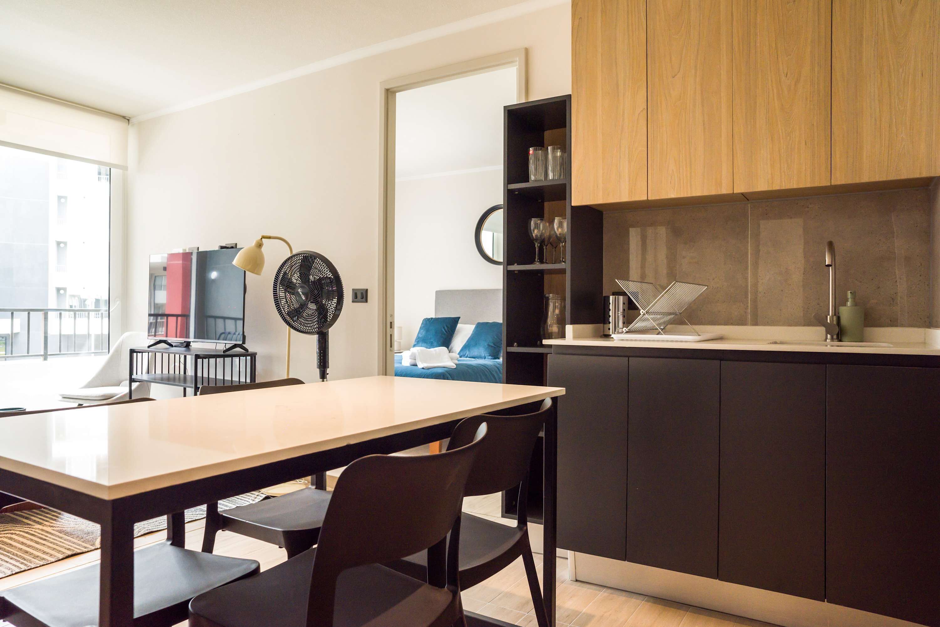 Une cuisine moderne avec des meubles de couleur sombre, un plan de travail en bois et un évier encastré.