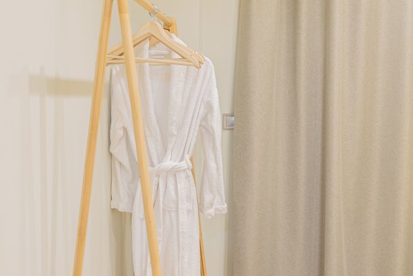 A wooden hanger with a white robe hanging on it. -  COZY NEWLY BUILD BY THE SEA APARTMENT IDEAL FOR FAMILIES (Katakolo)