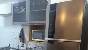 A modern kitchen with a stainless steel refrigerator, a microwave, and a sink. - Apartment in Summer Park (Florianópolis)