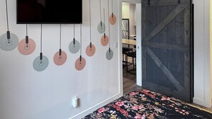A room with a bed, a TV mounted on the wall, and a sliding barn-style door. - Red Pine Retreat at Canyons Village (Park City)