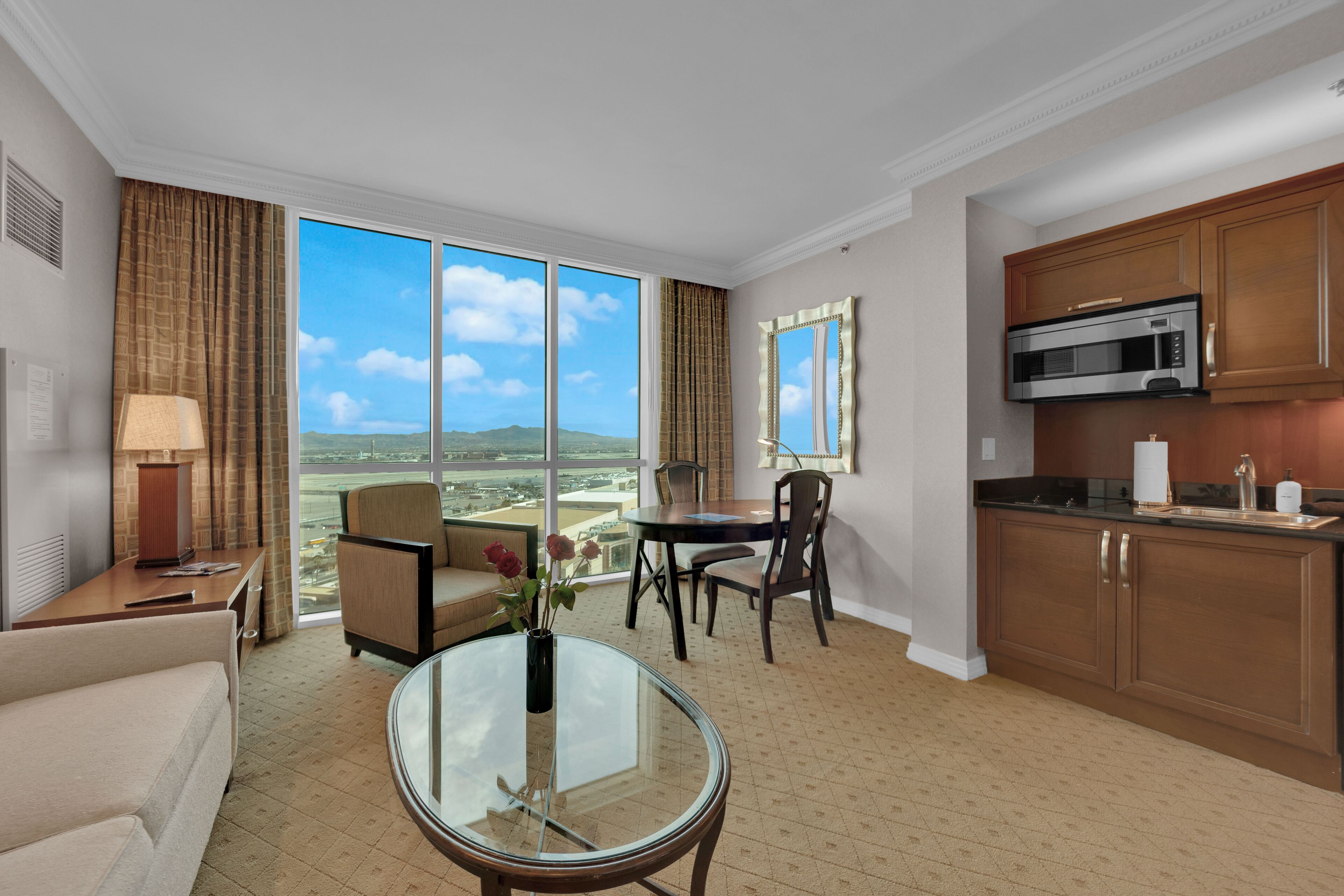 Ein Hotelzimmer mit Essbereich, einer Küche mit Mikrowelle und einem großen Fenster mit Blick auf die Landschaft.