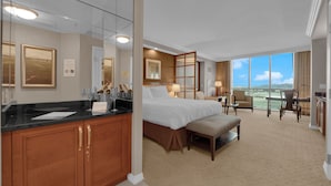 Une chambre d’hôtel avec un grand lit, un bureau, une chaise et un balcon avec vue.