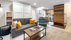 A compact living space with a grey sofa, a wooden coffee table, and a kitchenette in the background. - Relaxing Canyons Condo Free Shuttle Ride To Lift (Park City)