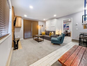 A modern living room with a sofa, armchair, coffee table, and a wooden dining table. - Relaxing Canyons Condo Free Shuttle Ride To Lift (Park City)