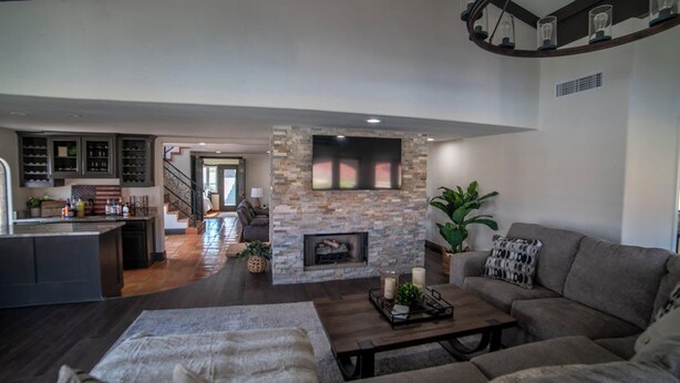A spacious living room with a stone fireplace, a large flat-screen TV, and a comfortable seating area. - Gorgeous Hacienda on the River! Private Dock! (Parker)