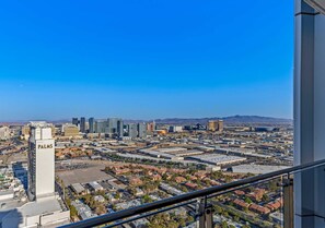 Une vue d’une ville avec un bâtiment imposant portant l’inscription « PALMS » et un ciel d’un bleu clair.