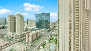 A high-rise building with a modern glass facade, surrounded by other tall buildings and a busy street with cars and pedestrians. - Mirai MGM (Las Vegas)