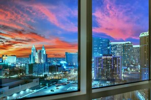 A cityscape at dusk with illuminated buildings and a parking area visible through a window. - Kintsugi Retreat-condo-balcony-stripview (Las Vegas)