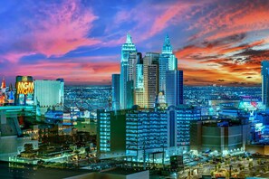A cityscape with prominent skyscrapers, including a tall building with a pointed top and another with a rounded top. - Kintsugi Retreat-condo-balcony-stripview (Las Vegas)
